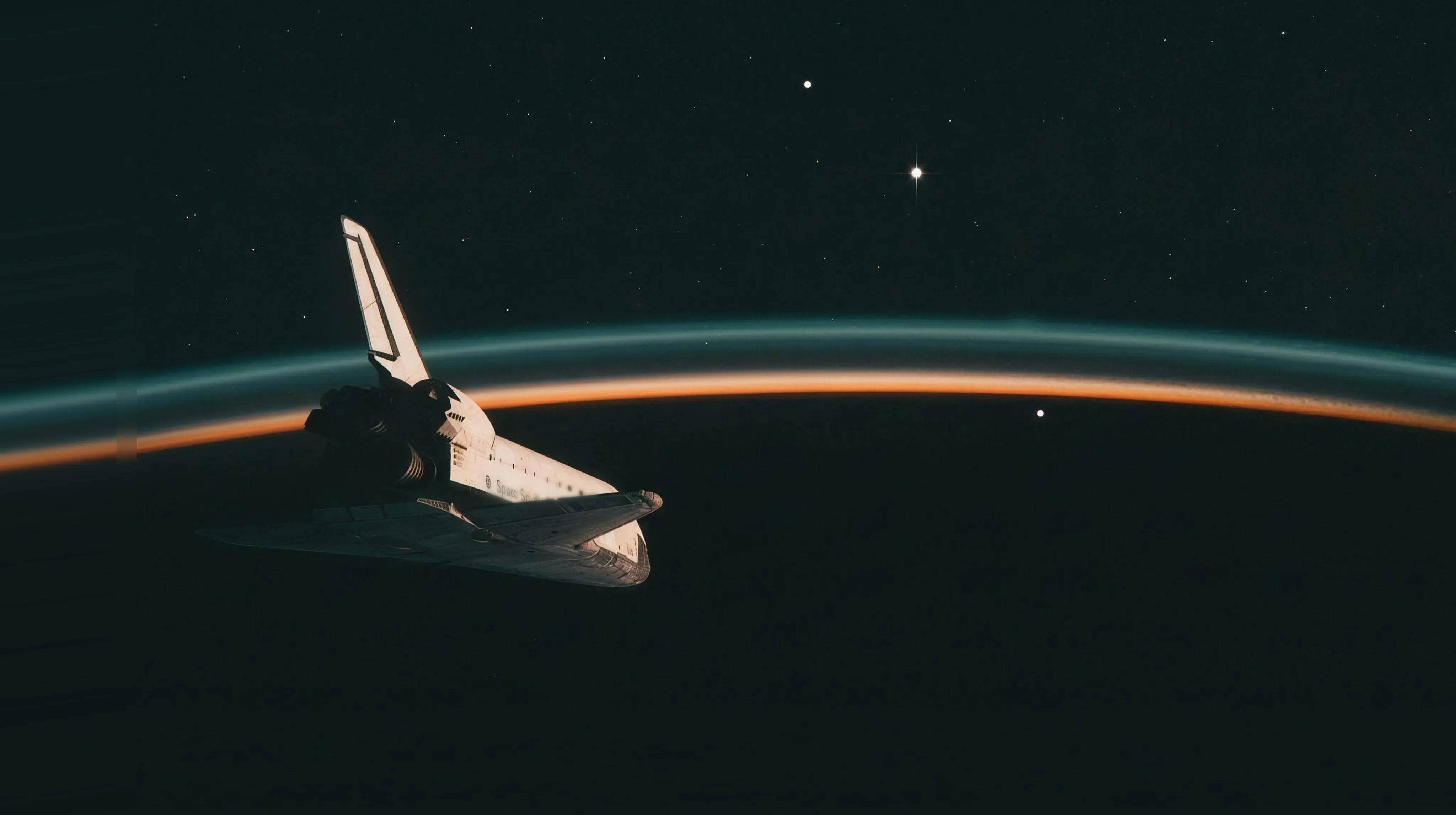 The Space Shuttle orbiter seen from outside in low Earth orbit at orbital dawn: the orbiter rides in the lower left as a mostly dark silhouette, tail and OMS pods toward the viewer, its upper surfaces rimmed in warm dawn light; the Earth's limb sweeps across the frame as one long shallow curve, the night side almost black, capped by a brilliant thin band of dawn orange under a soft teal airglow line; above the limb, three small bright points of light lie along a shallow descending arc like a multiple exposure, the middle one distinctly brighter with a four-spike glint, the third sitting just below the limb line against the dark Earth; sparse stars above, no moon.